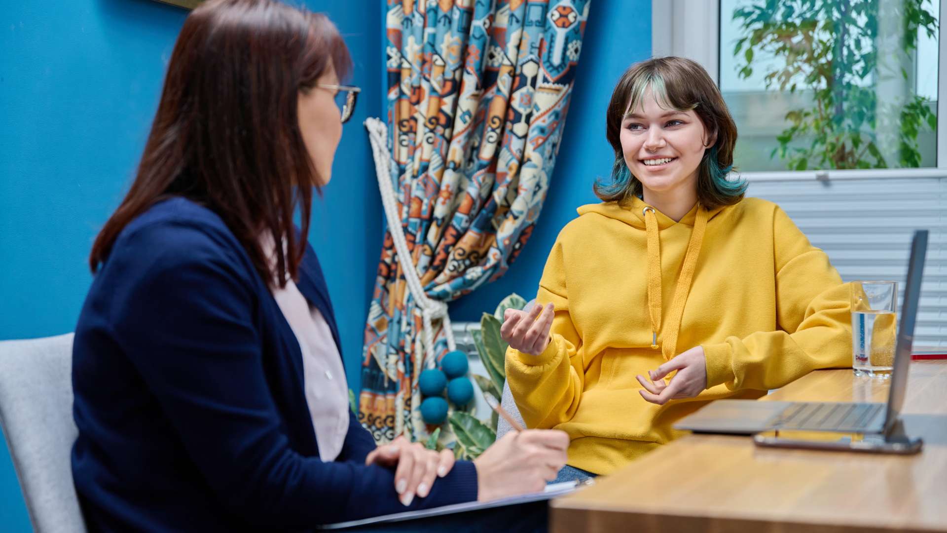Silver State Adolescent Treatment Teen Woman With Colorful Hair Talking to Therapist Next to Computer